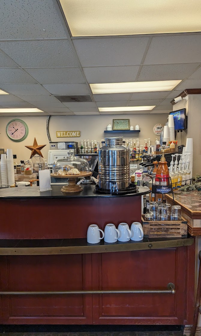 The red service counter at The Grind Coffee House with espresso machine and mugs